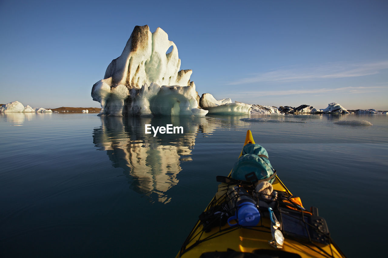 Stern of a sea kayak floating towards an iceberg on a glacier lagoon