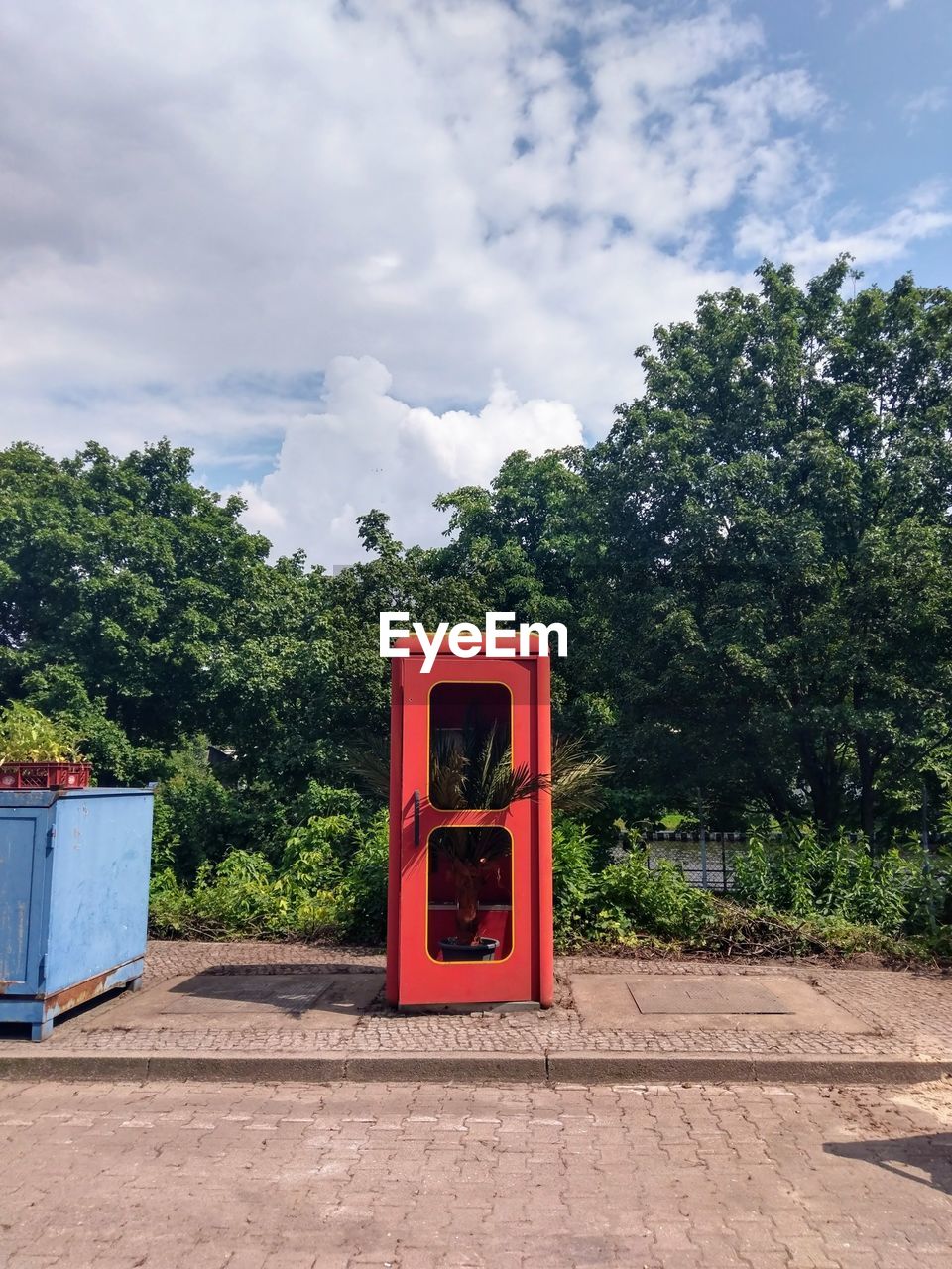 Telephone booth by trees against sky