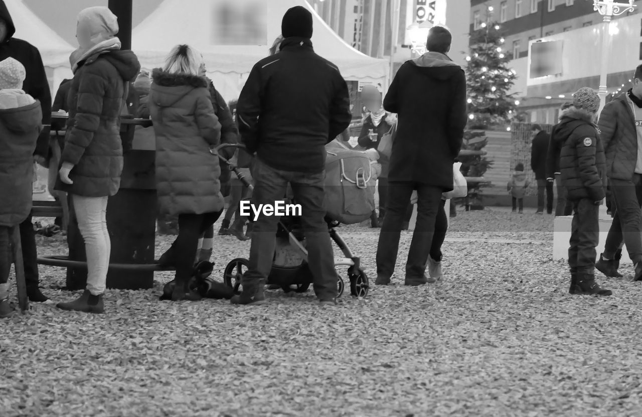 GROUP OF PEOPLE WALKING ON STREET IN CITY