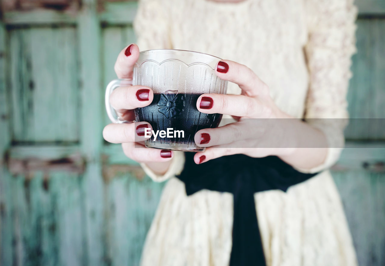 Midsection of woman holding fresh drink