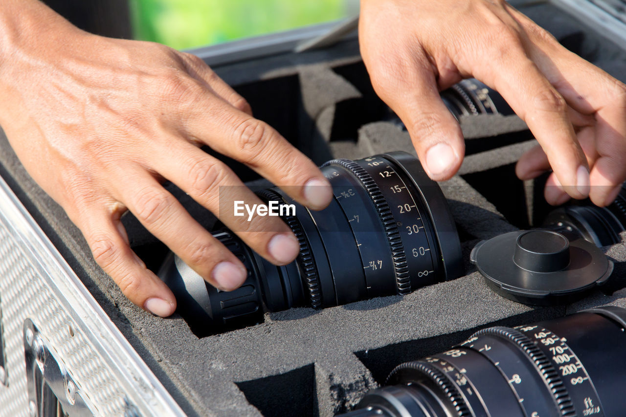 Cropped image of man keeping camera in suitcase