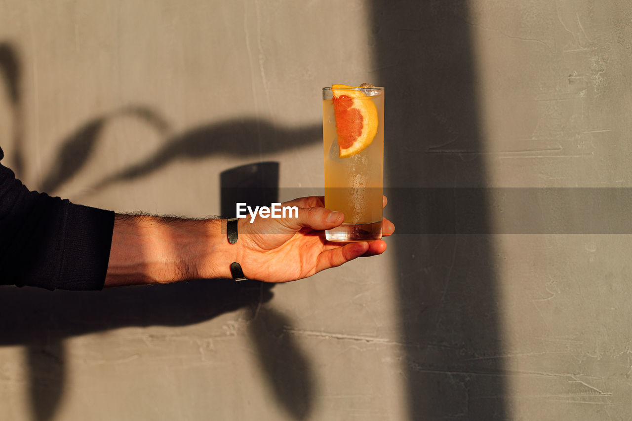 cropped hand of woman holding toy on wall