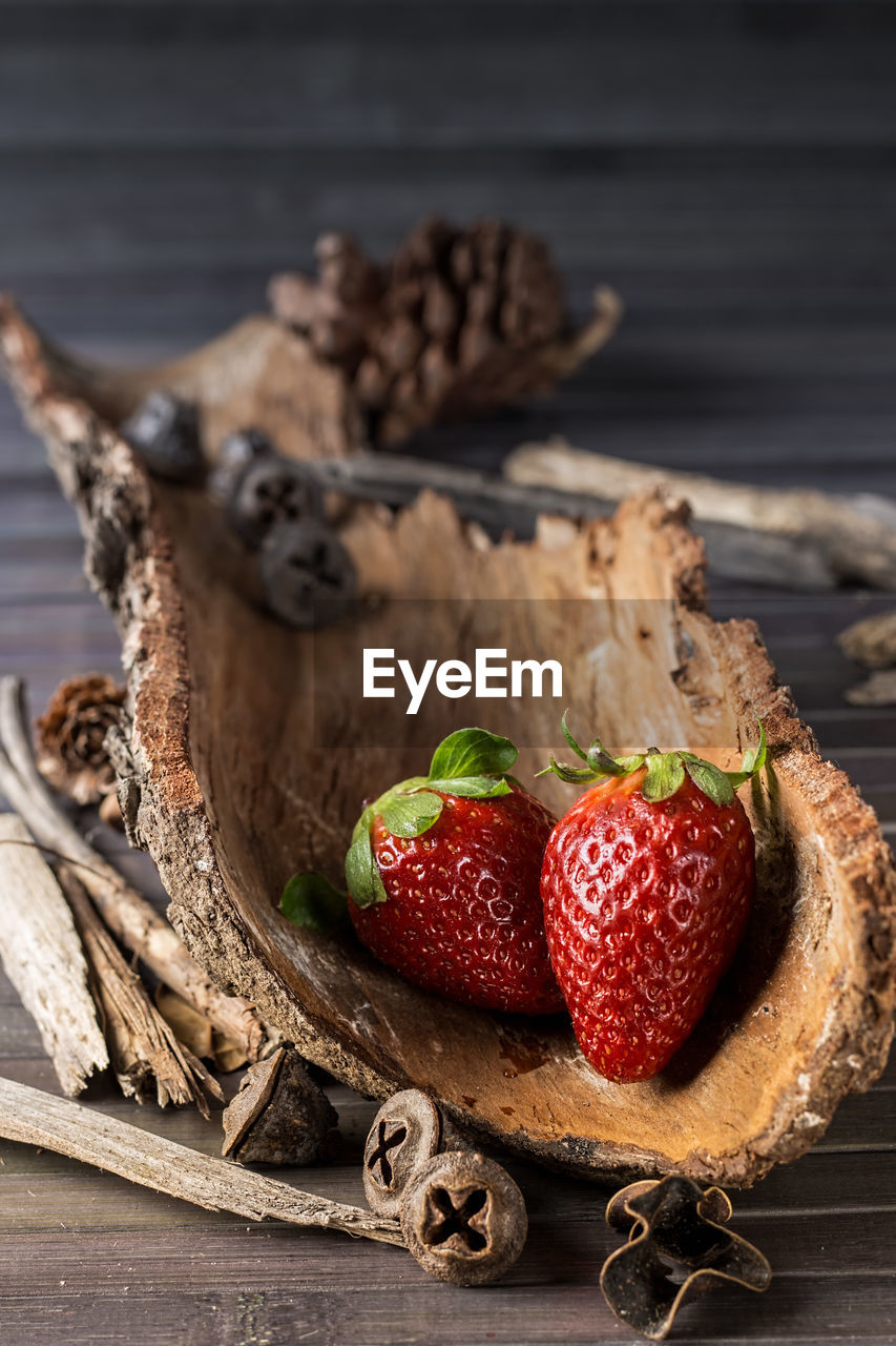 Strawberries with rustic decor in a wooden table. vertical image.