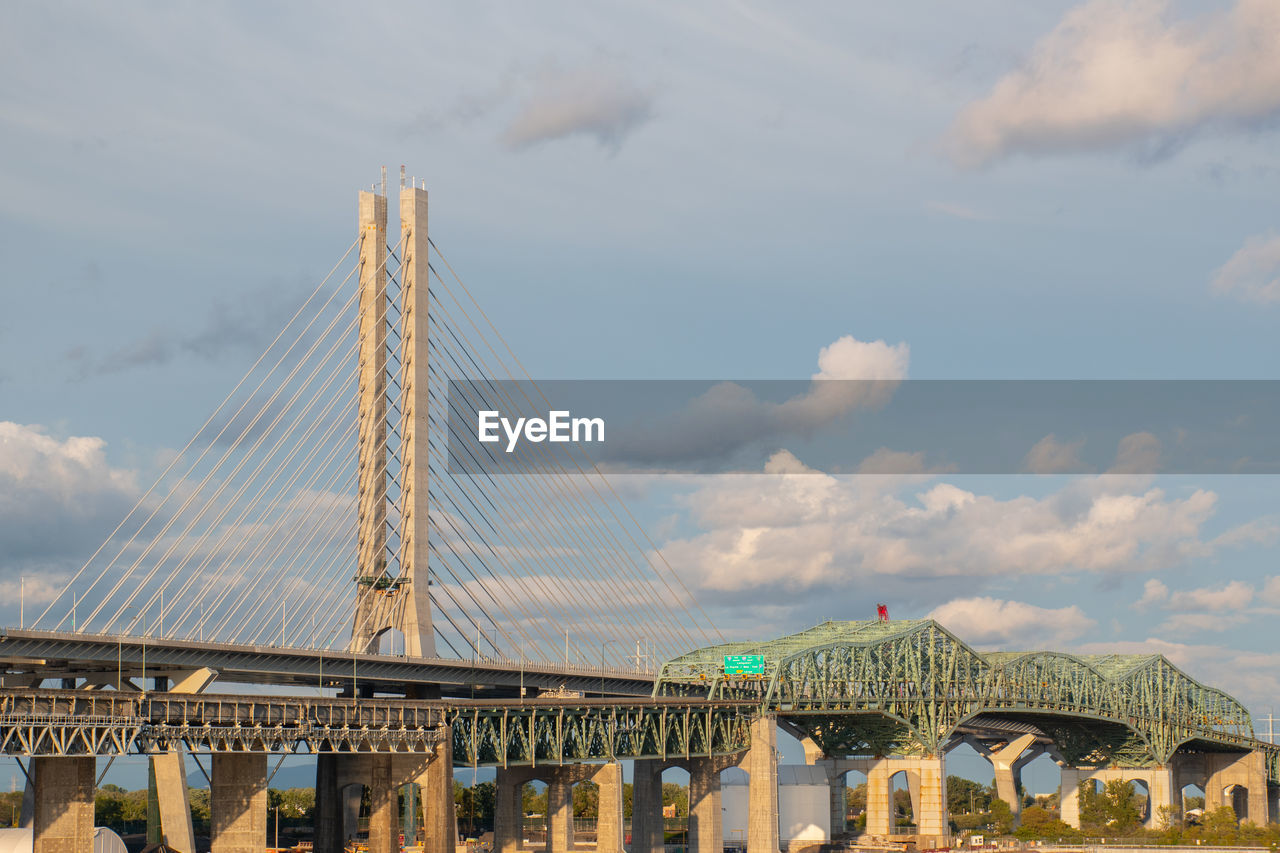 Low angle view of bridge against cloudy sky