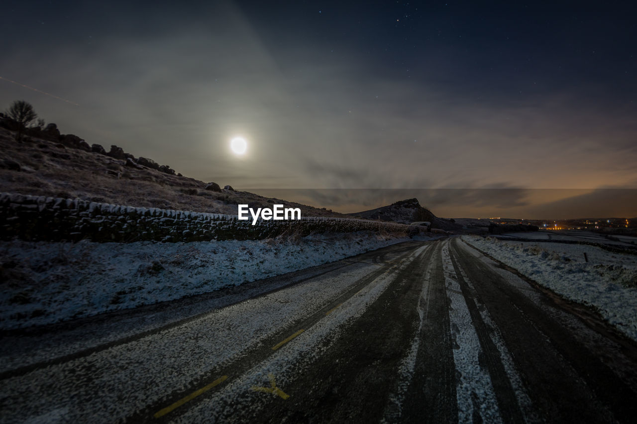 Panoramic view of snow covered landscape against sky at night
