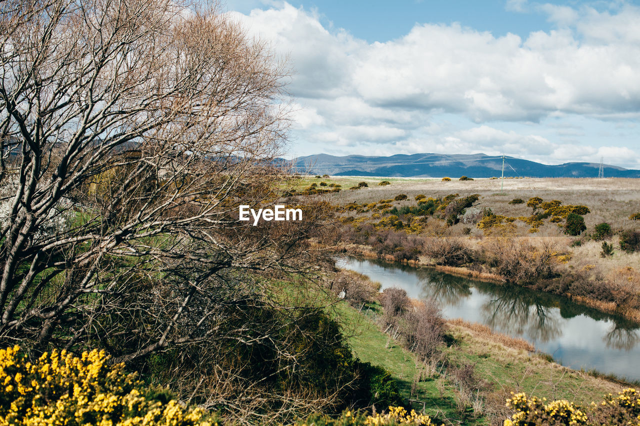 Stream by landscape against sky