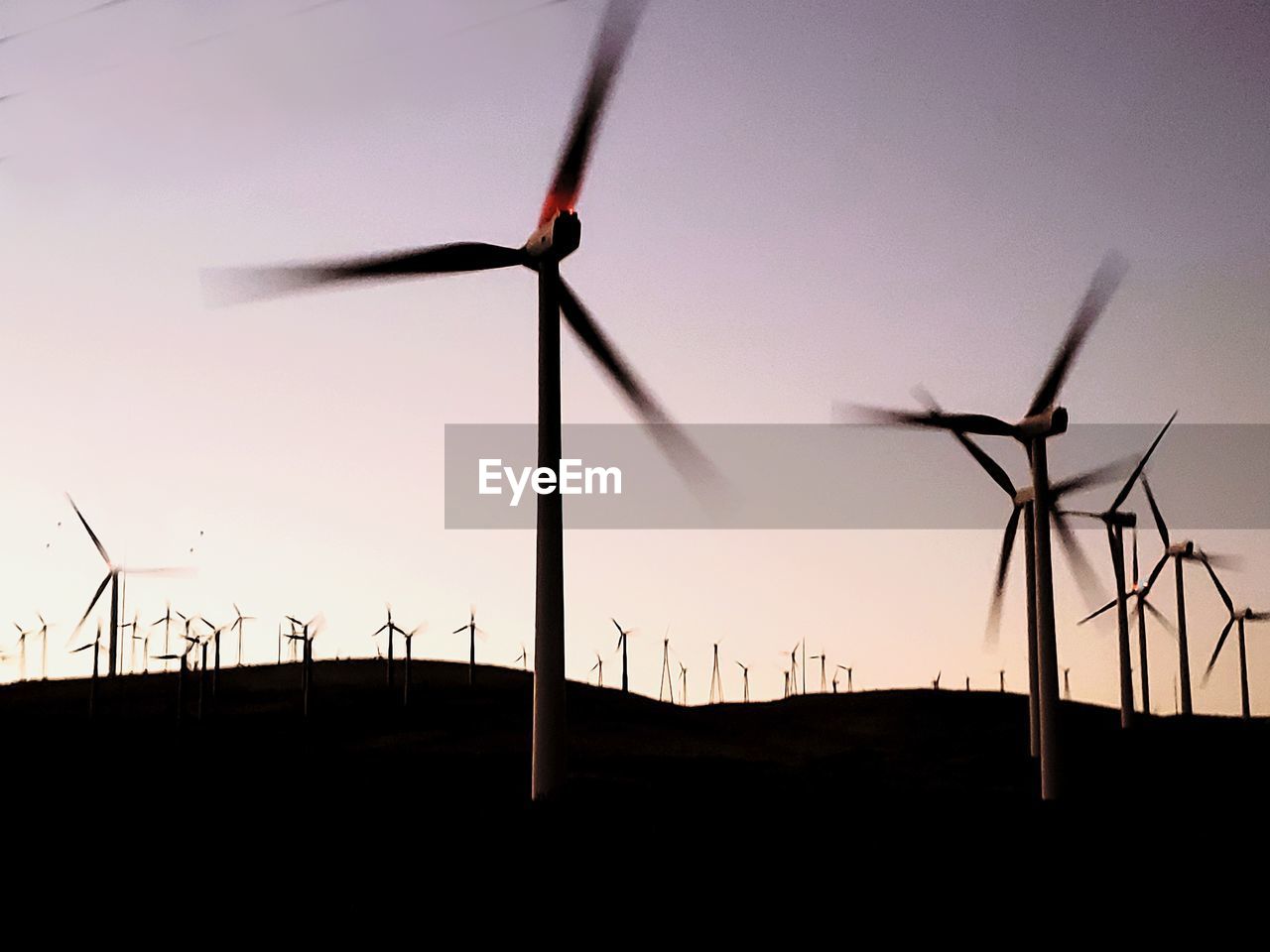 SILHOUETTE WIND TURBINES ON FIELD AGAINST SKY