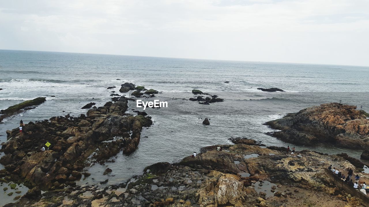 ROCKS ON SEA AGAINST SKY