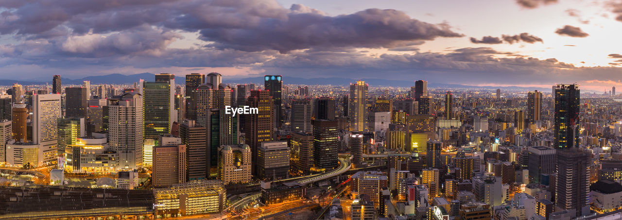 Aerial view of cityscape against cloudy sky