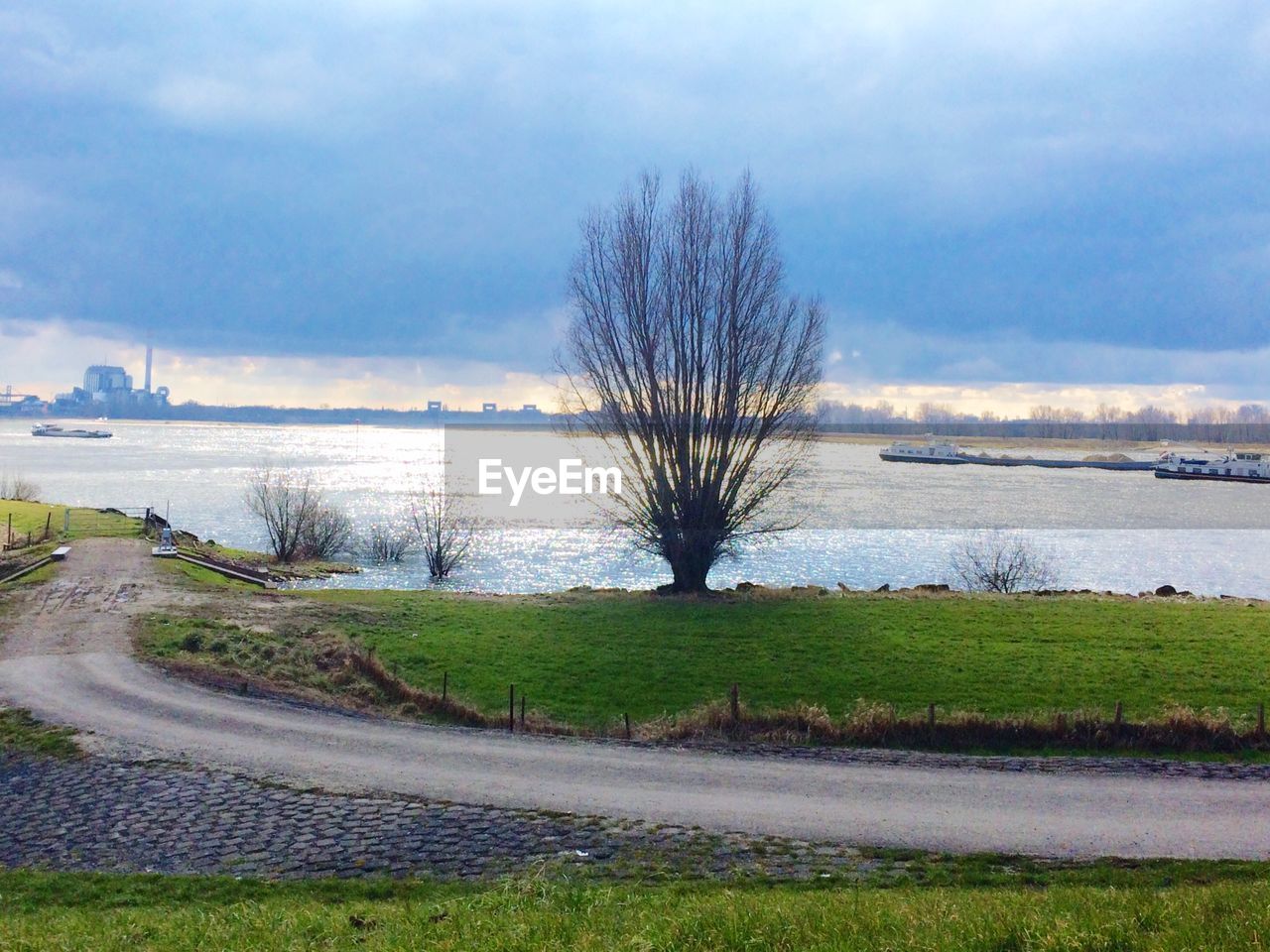 SCENIC VIEW OF RIVER WITH CLOUDY SKY IN BACKGROUND