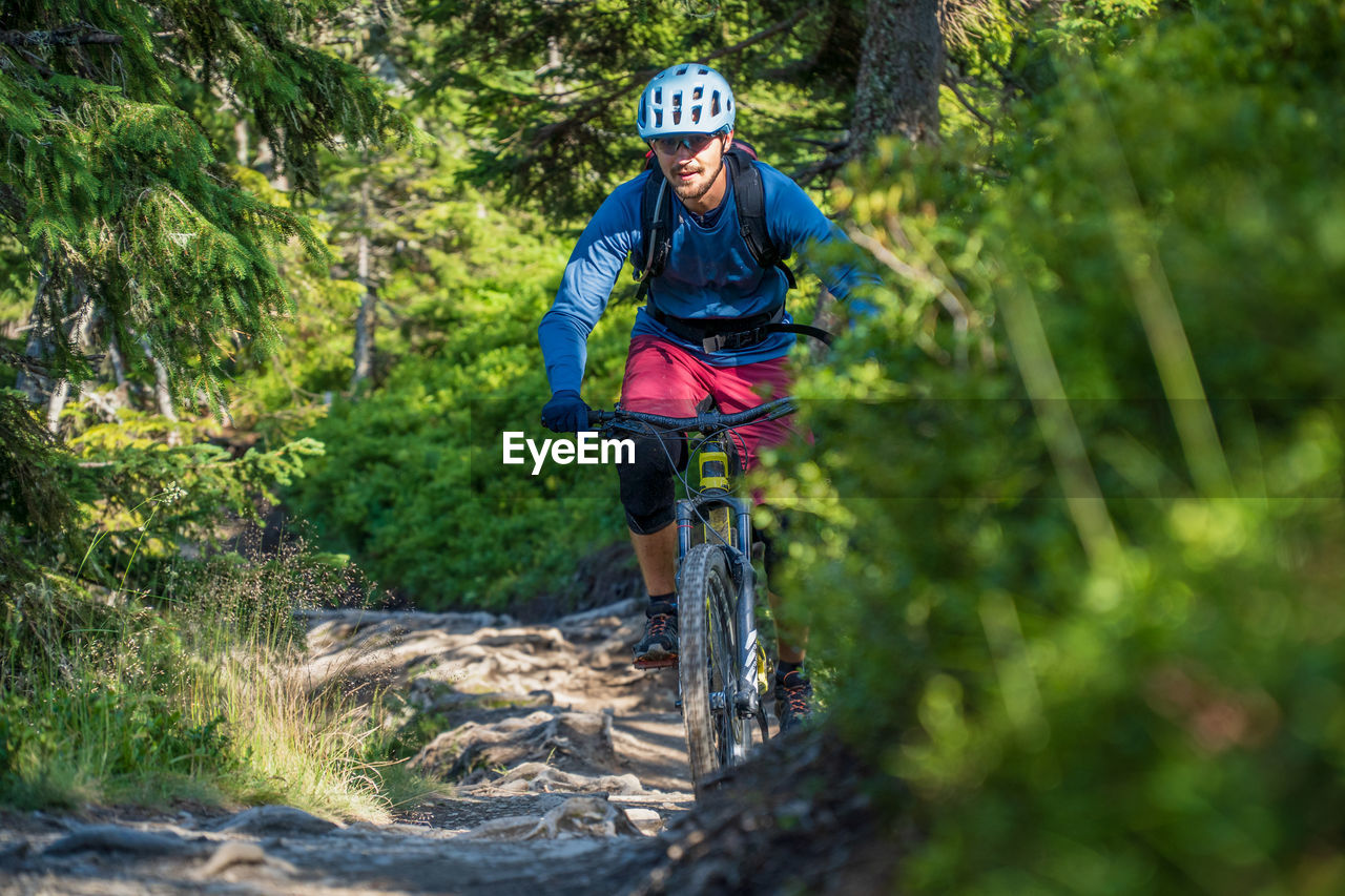 Man riding a mountain bike on footpath in the austrian alps, saalbach, austria