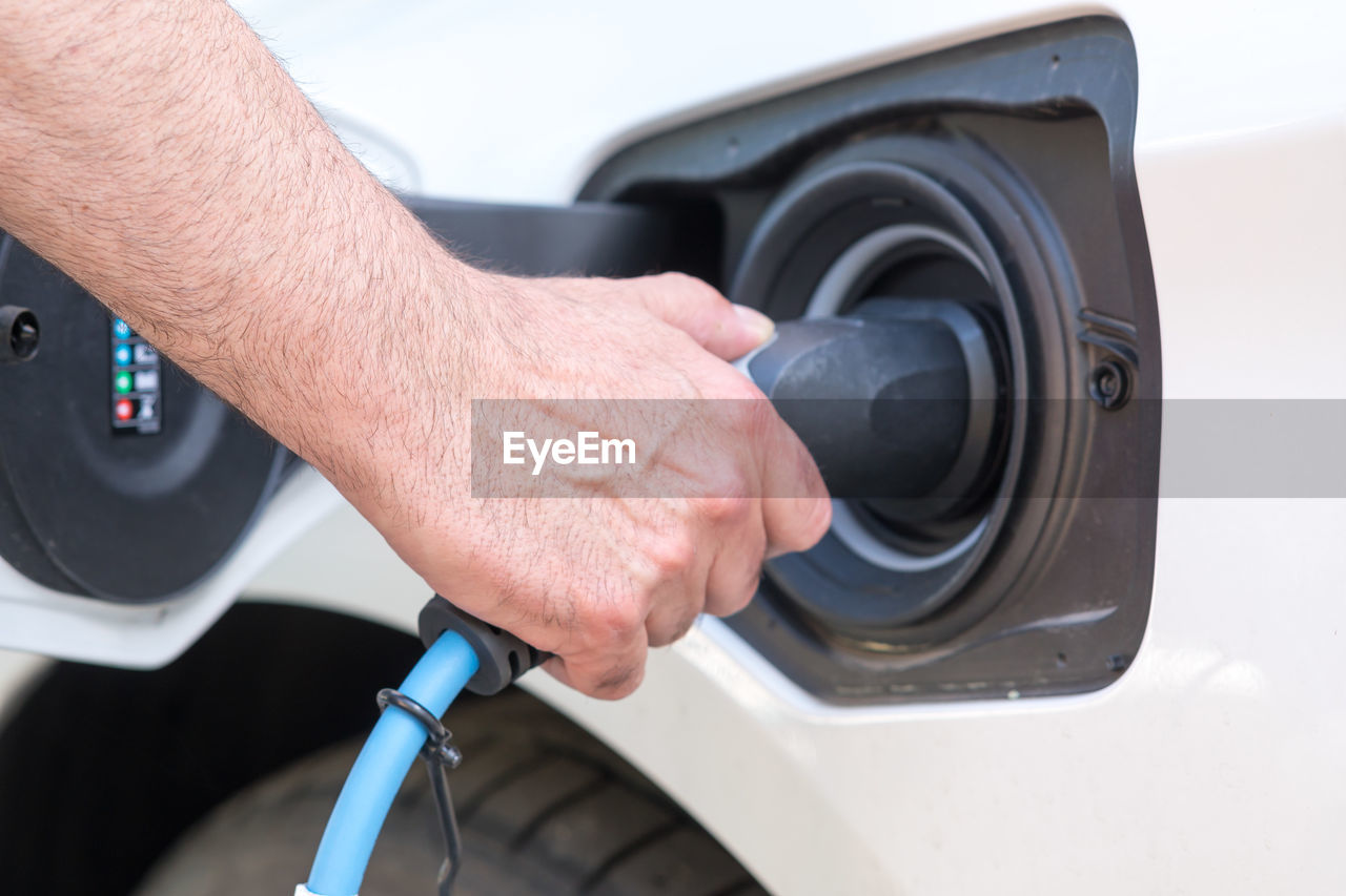 Man hand holding an electric vehicle charging connector