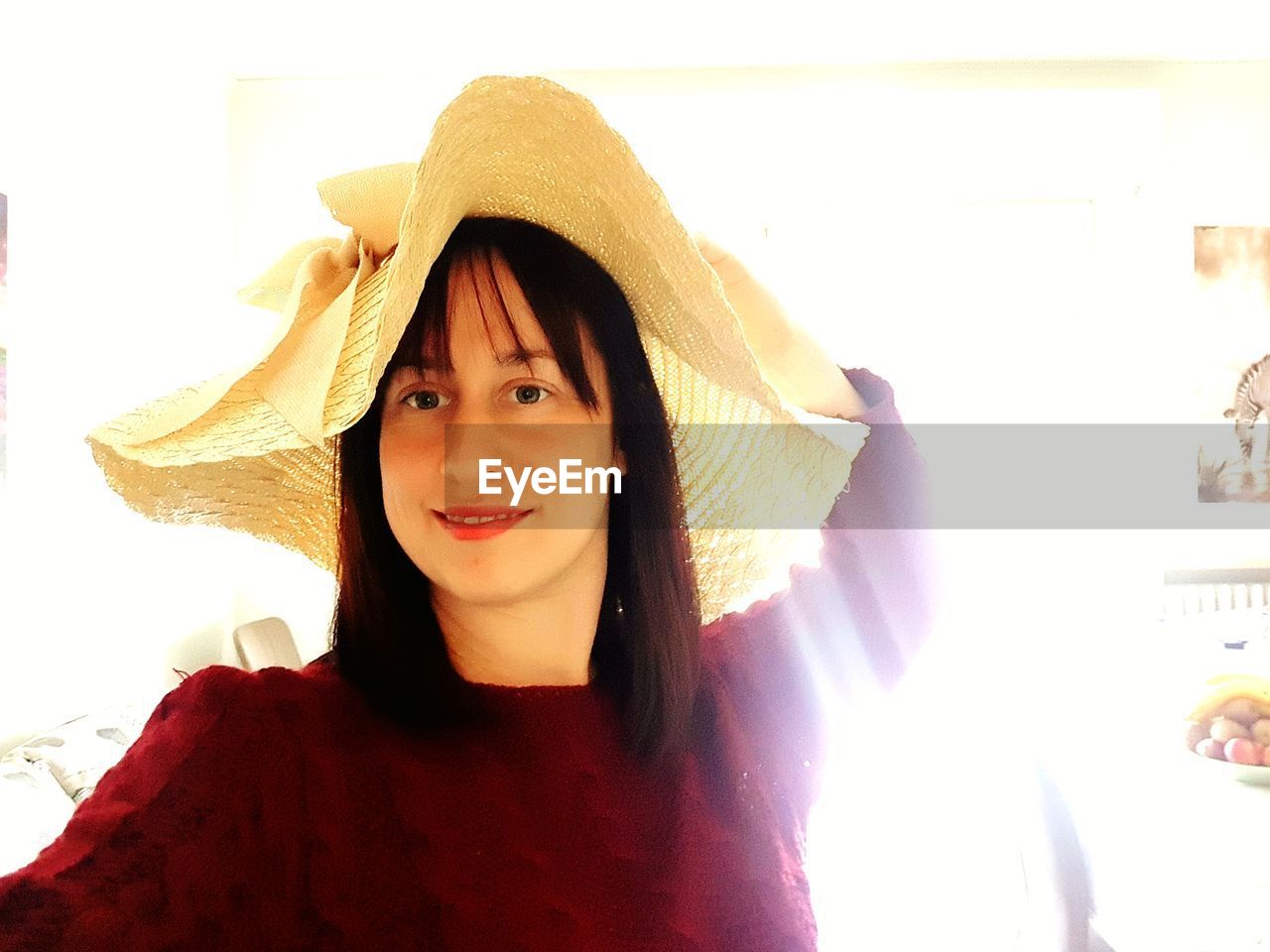 PORTRAIT OF SMILING YOUNG WOMAN WITH HAT