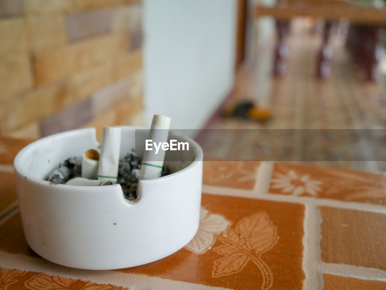 Close-up of cigarette butts in ashtray on table at home