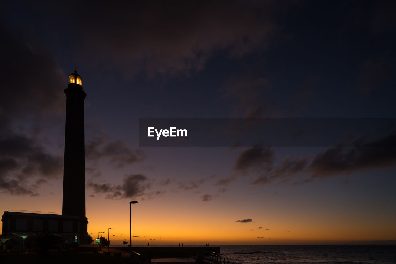 Low angle view of silhouette lighthouse against sky during sunset