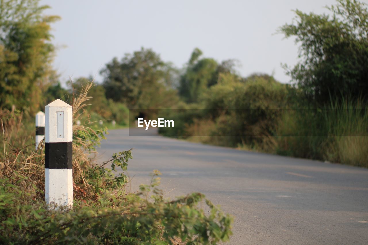 Close-up of kilometer pole by road.