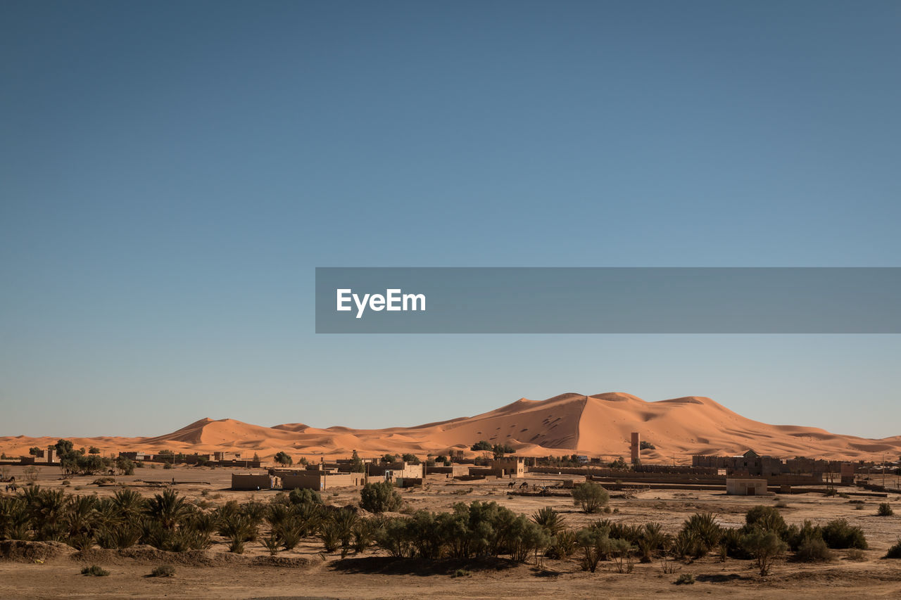 Scenic view of desert against clear blue sky