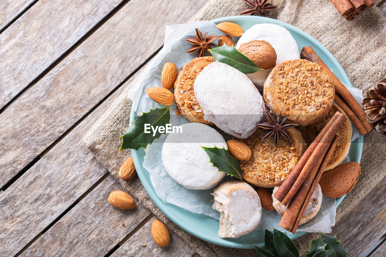 Traditional spanish christmas sweets, shortbread mantecados and polvorones on a wooden table