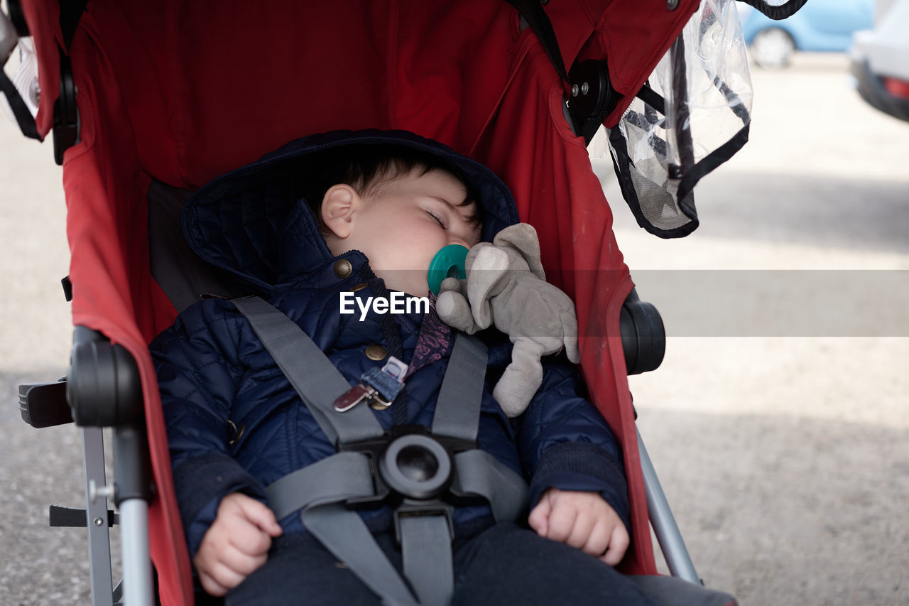 Young baby fell asleep in his stroller at the county fair