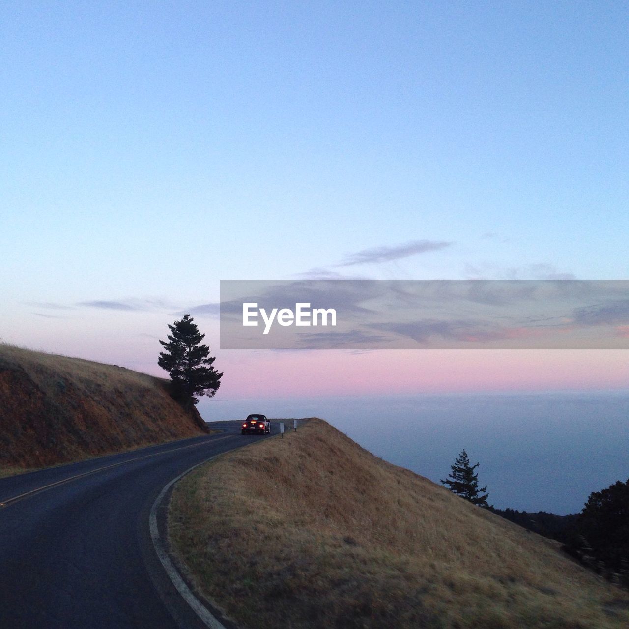 Street on mountain against sky during sunset