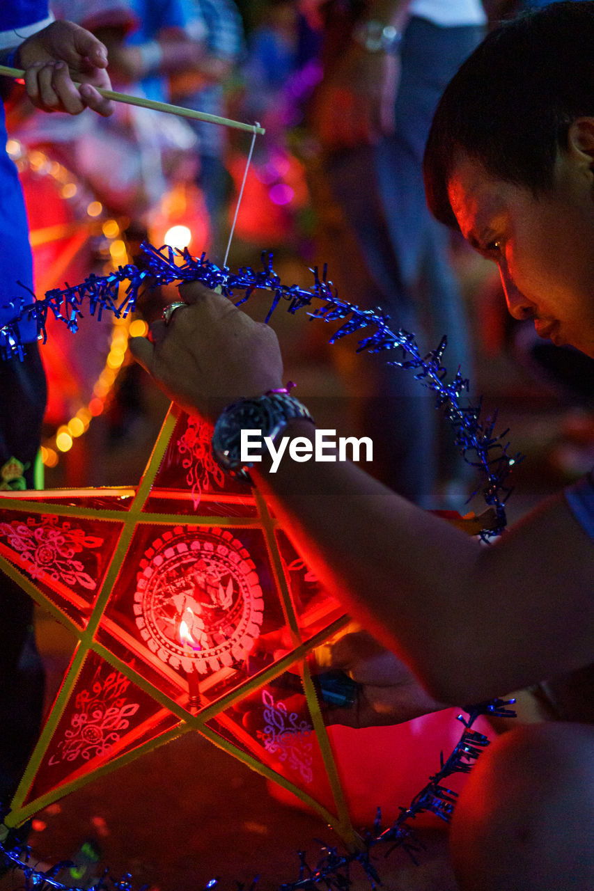 Man making illuminated decoration at workshop