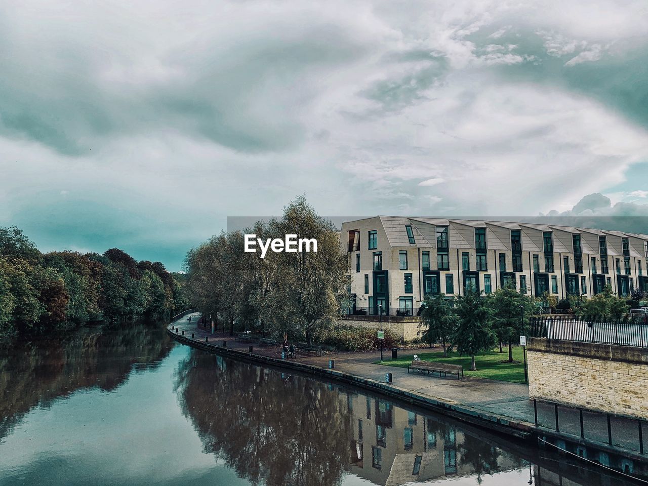 Canal amidst buildings against sky in city