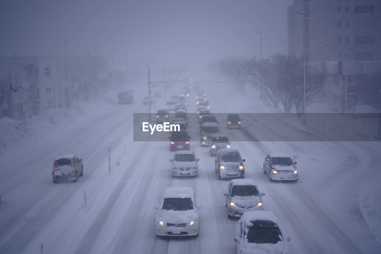 HIGH ANGLE VIEW OF TRAFFIC ON ROAD DURING WINTER