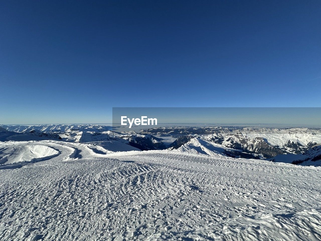 landscape, environment, snow, winter, cold temperature, scenics - nature, mountain, mountain range, sky, blue, beauty in nature, nature, piste, plateau, tranquil scene, no people, tranquility, clear sky, non-urban scene, extreme terrain, day, copy space, travel, frozen, outdoors, white, travel destinations, remote, land, idyllic, snowcapped mountain, horizon over land, polar climate, ice, horizon, ridge