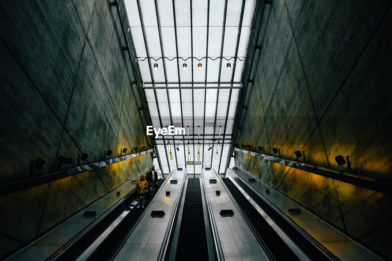 Low angle view of people on escalators in subway station