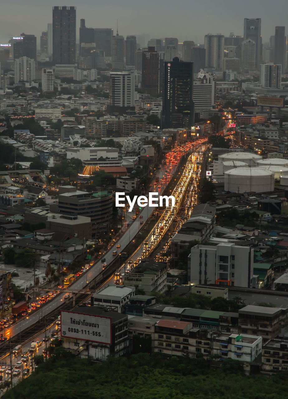 HIGH ANGLE VIEW OF ILLUMINATED CITY BUILDINGS AGAINST SKY