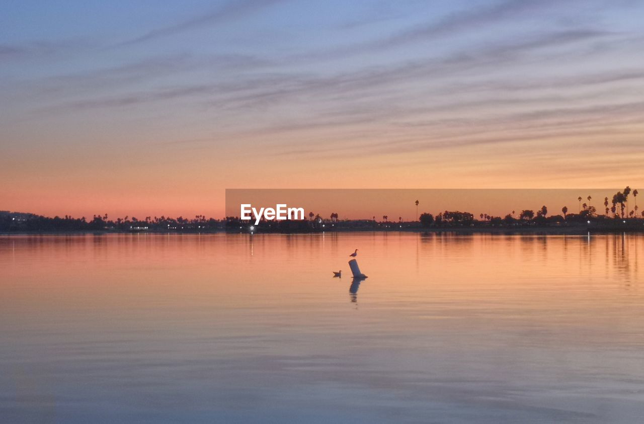 SCENIC VIEW OF LAKE AGAINST ORANGE SKY