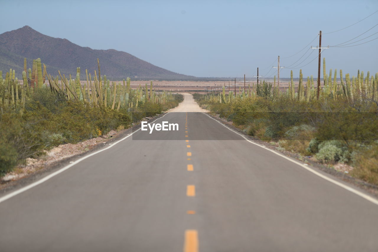 ROAD PASSING THROUGH MOUNTAINS AGAINST SKY