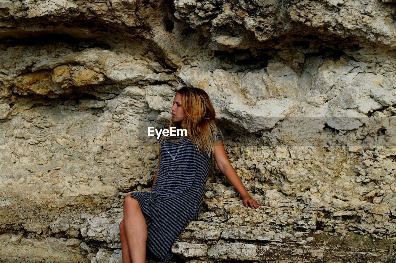 Woman sitting on rock formation