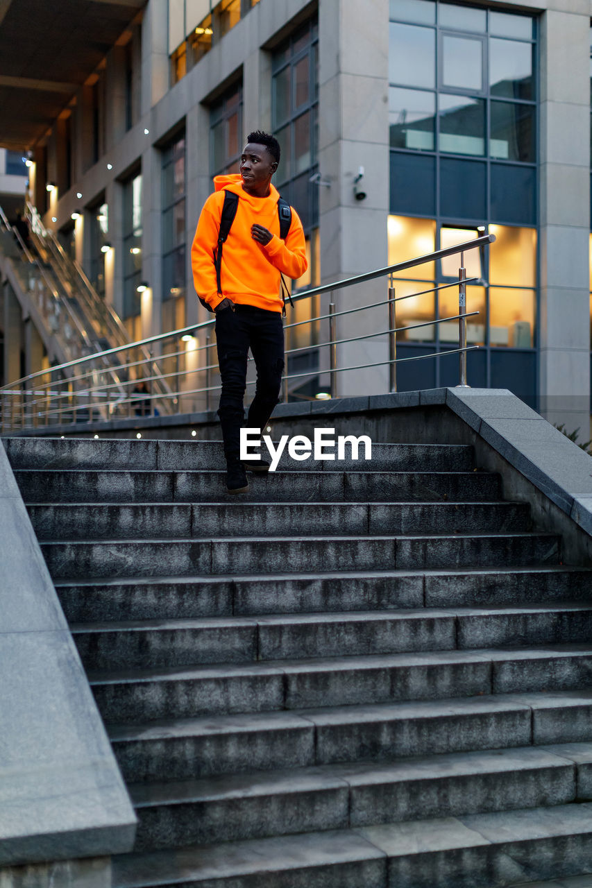 full length of young man walking on staircase