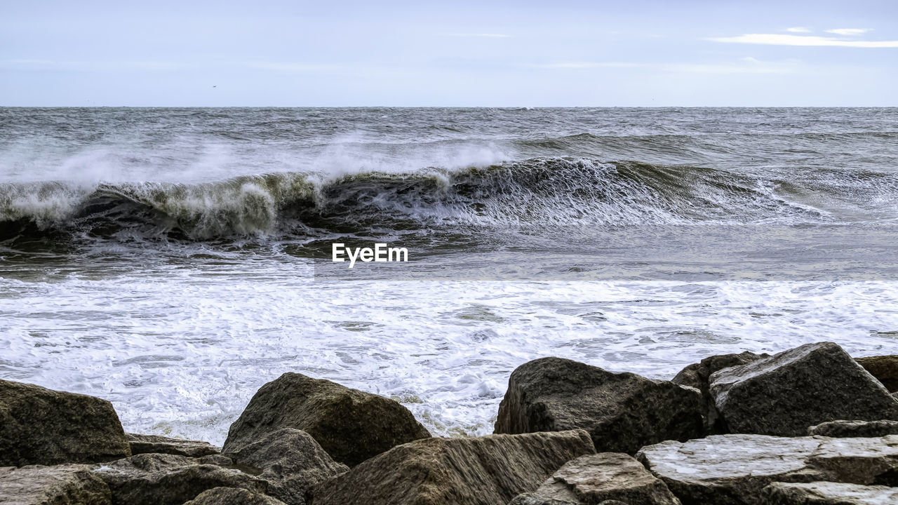 ROCKS IN SEA AGAINST SKY