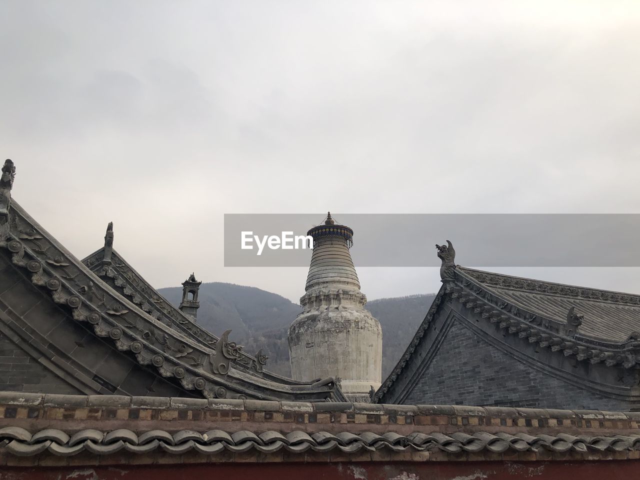 LOW ANGLE VIEW OF TEMPLE ROOF AGAINST SKY