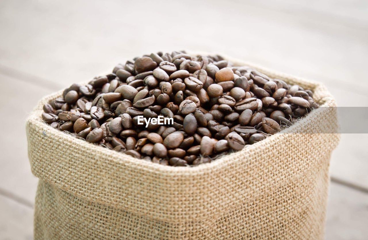 Roasted coffee beans in sack on table