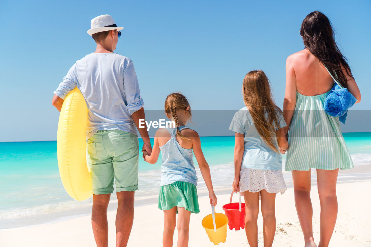 Rear view of family standing on beach