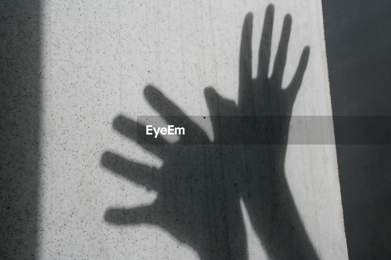 SHADOW OF PERSON TOUCHING WALL