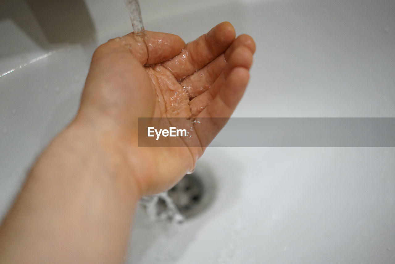 CLOSE-UP OF PERSON HAND IN WATER