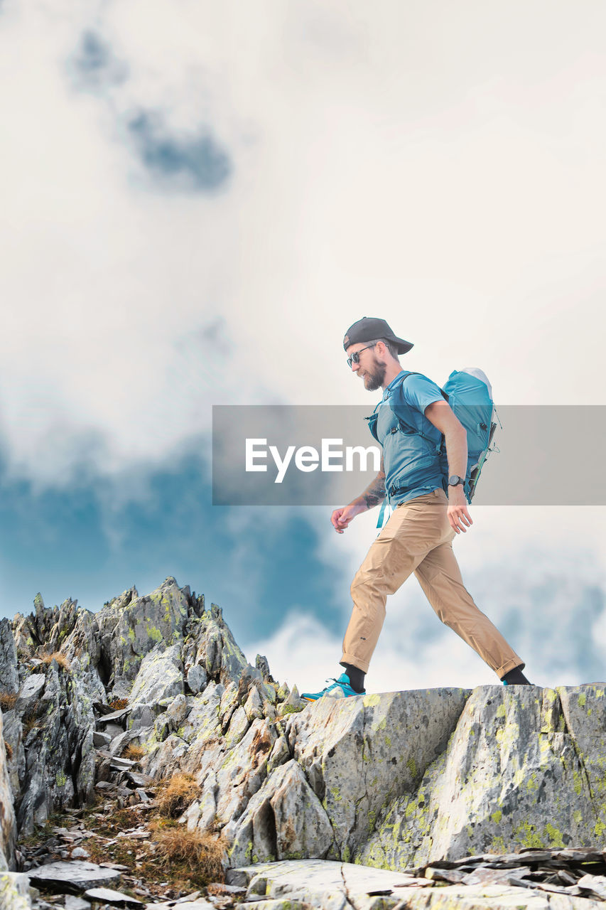 Man walks among boulders in the mountains in the italian alps