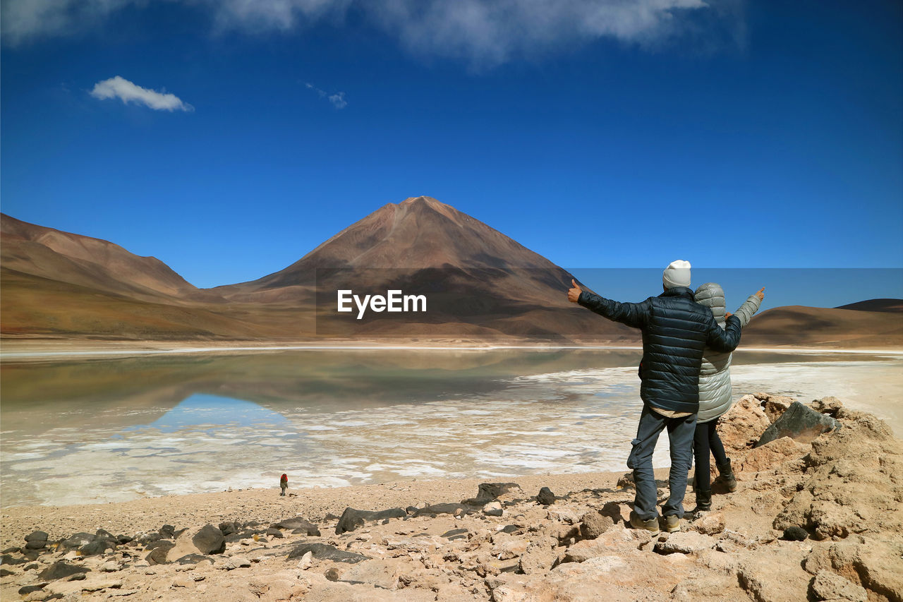 Rear view of couple standing against mountain