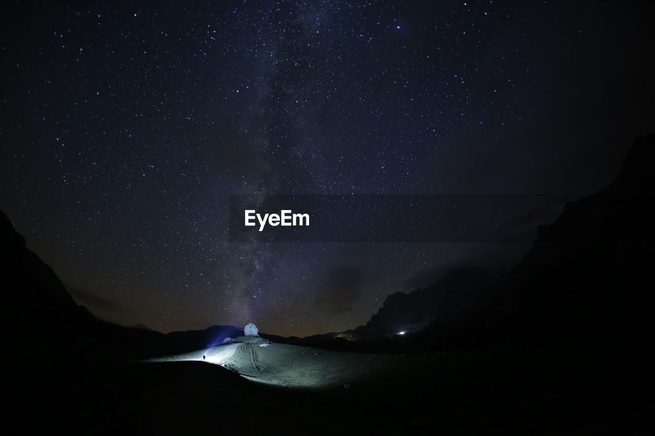 View of snow flakes against clear sky and silhouette mountain