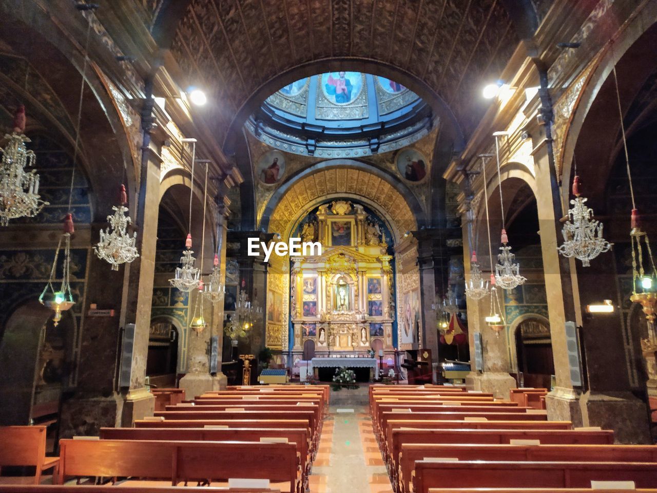 LOW ANGLE VIEW OF ILLUMINATED BUILDING IN CATHEDRAL