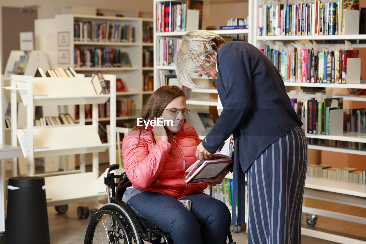 Woman on wheelchair talking to librarian