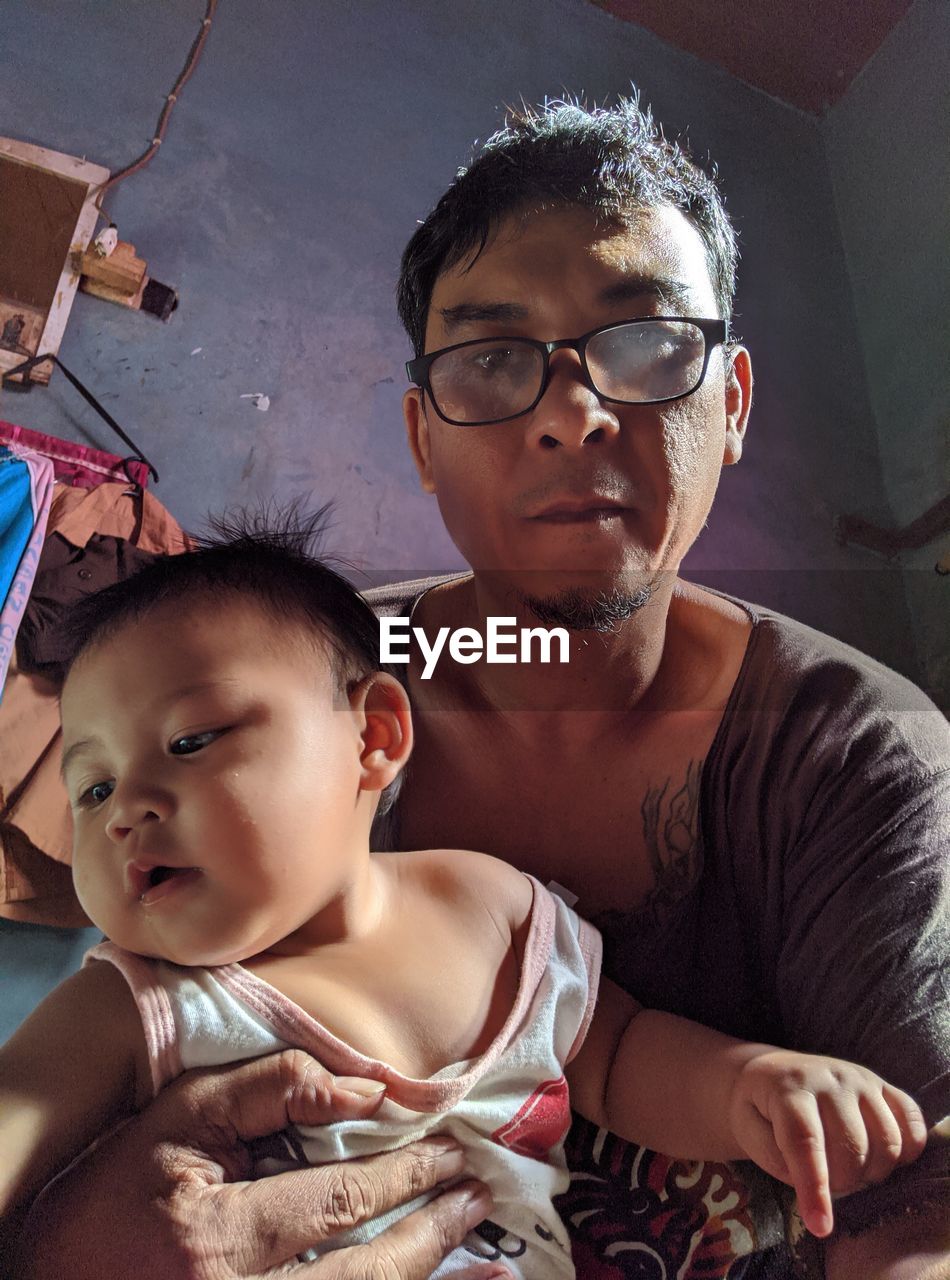 PORTRAIT OF FATHER AND BABY AT HOME