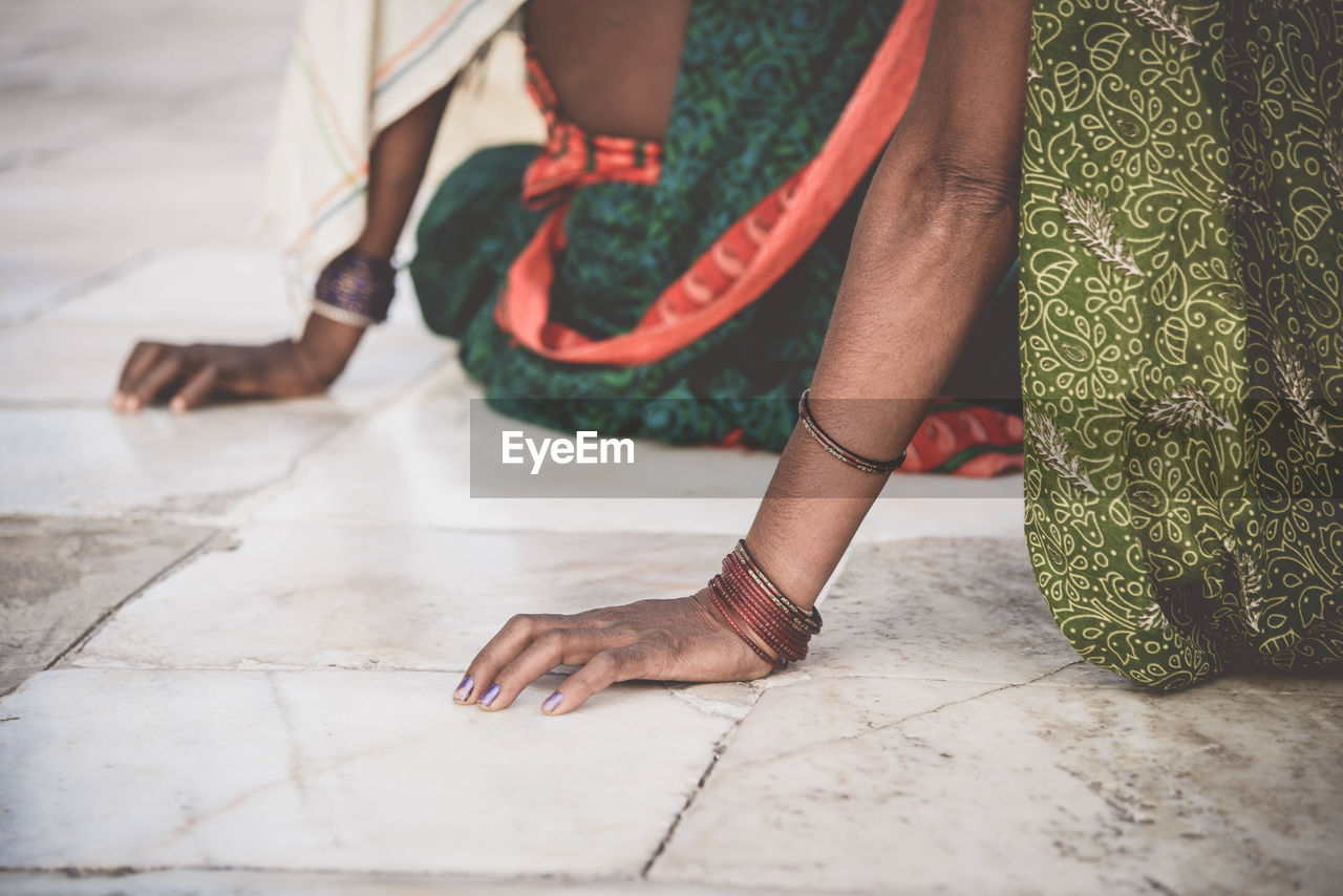 Close-up of human hand resting on floor