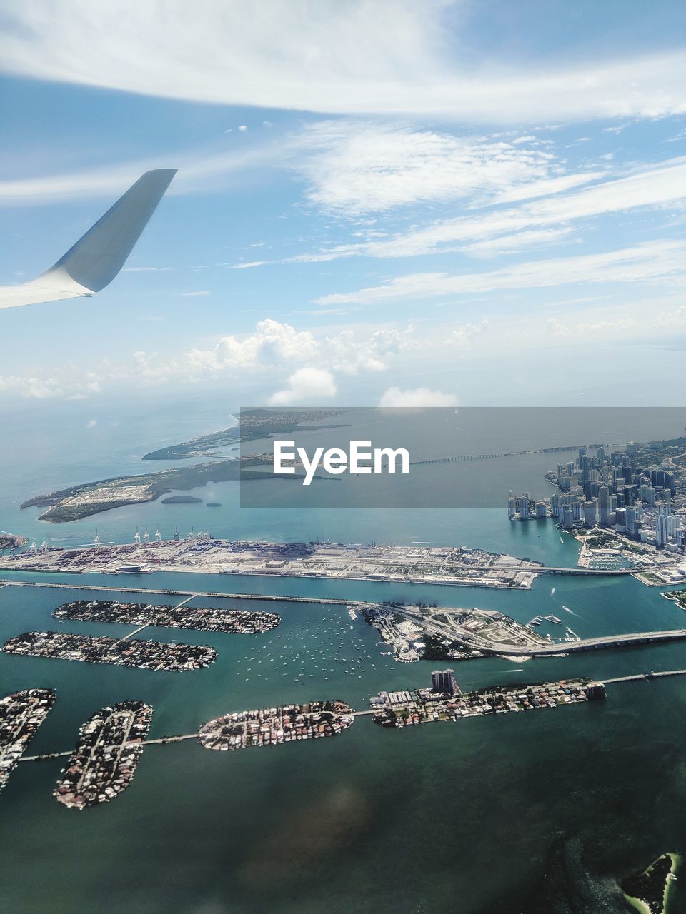 AERIAL VIEW OF SEA BY CITYSCAPE AGAINST SKY