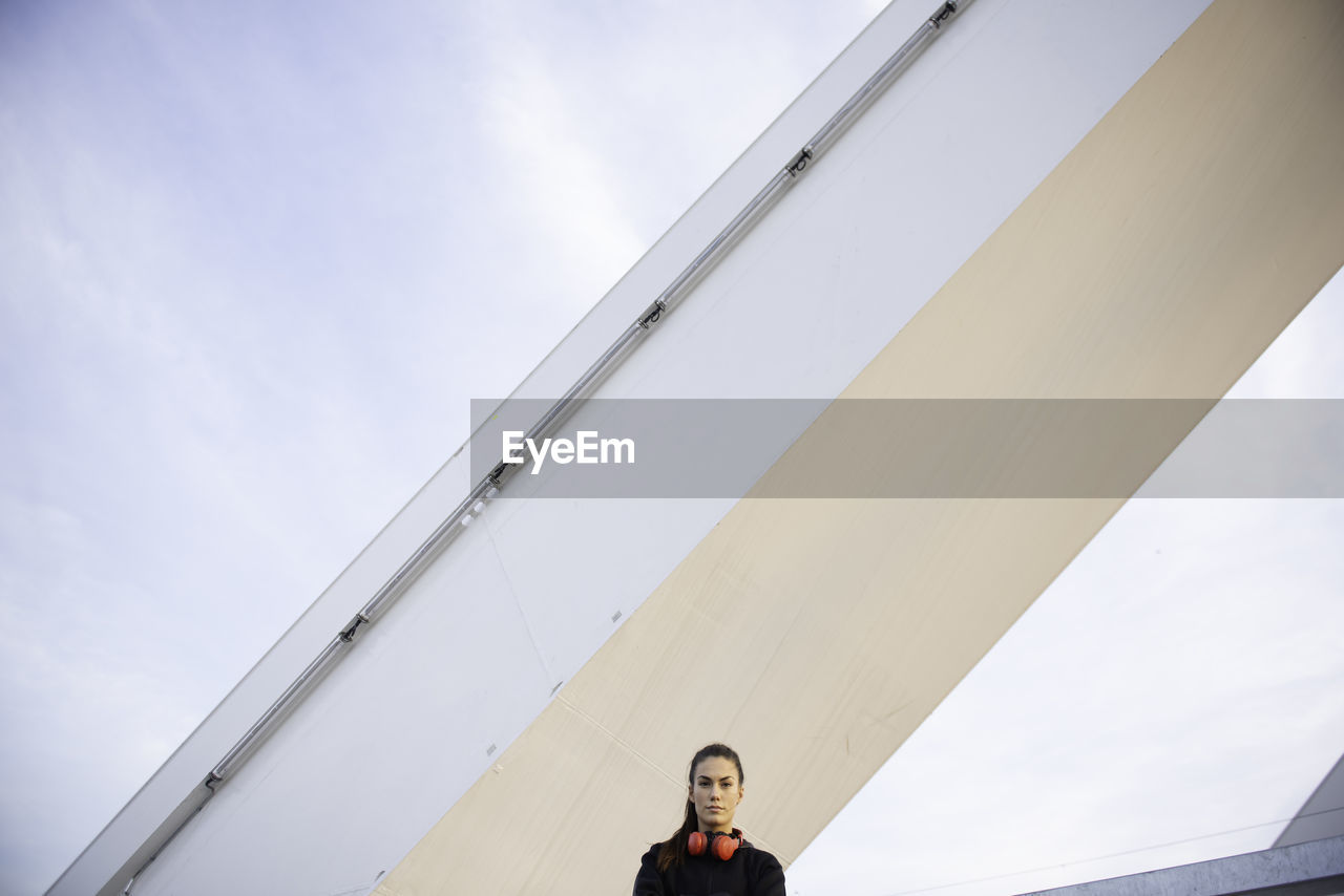 LOW ANGLE VIEW OF WOMAN AGAINST WHITE SKY