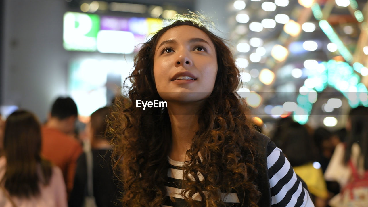 PORTRAIT OF BEAUTIFUL YOUNG WOMAN LOOKING AWAY OUTDOORS